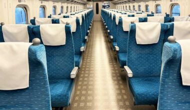 Foreign tourists in a group on the Shinkansen train block aisles and seats with their luggages