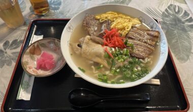 Large bowl of Okinawa Soba served with pork belly, boneless pork ribs, and a pork trotter.