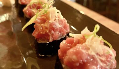 Bluefin tuna nigiri with feathered green scallions, ginger and lime